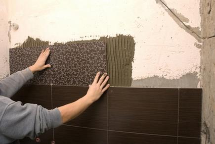 Man tiling a wall in the bathroom
